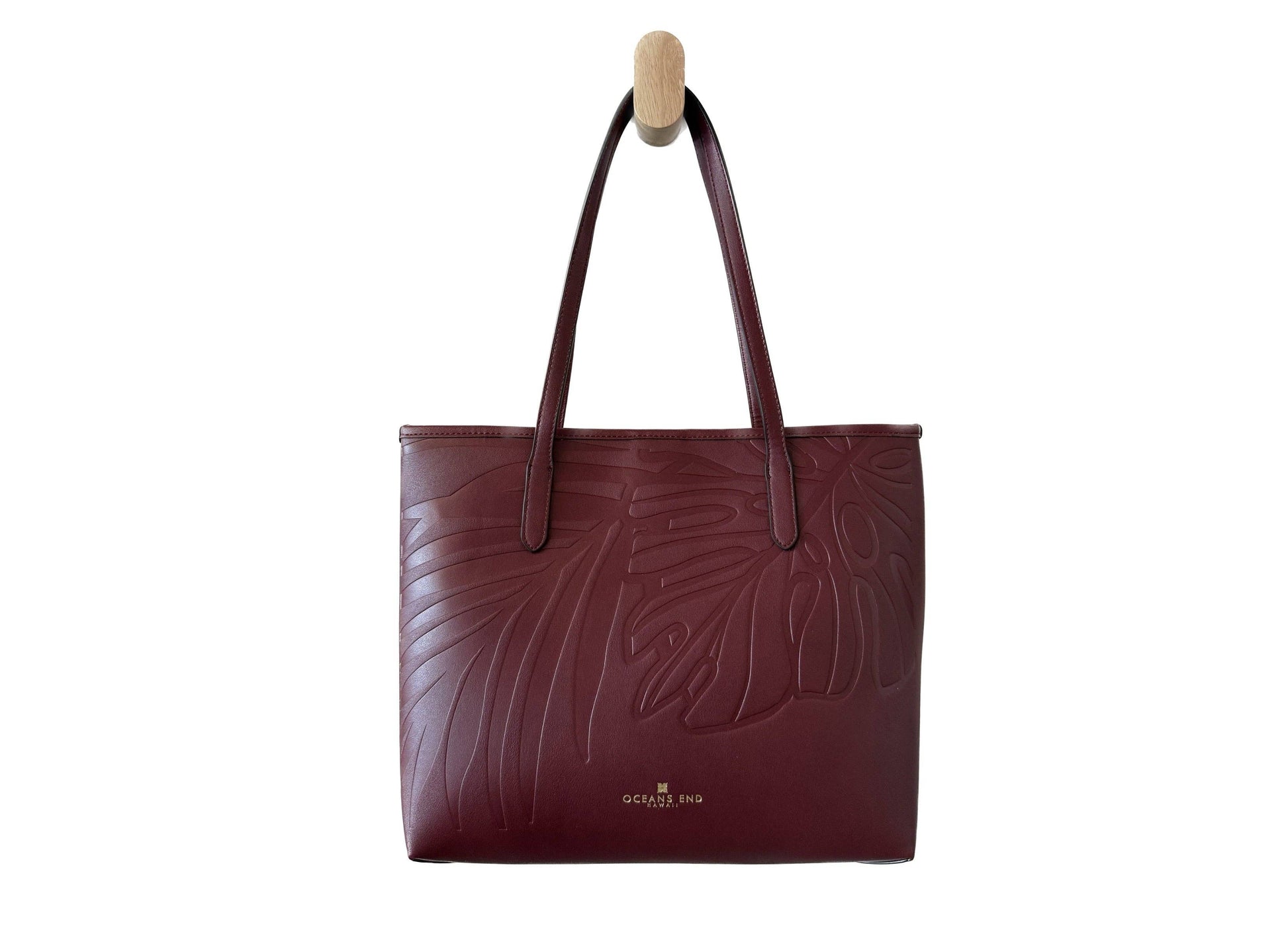 Burgundy handbag with leaf pattern embossed